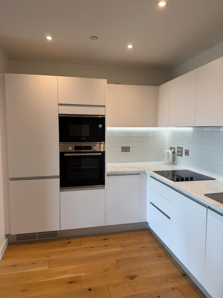 Bright white kitchen with fitted appliances